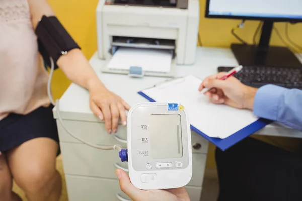 Médico verificando a pressão arterial do paciente — Fotografia de Stock