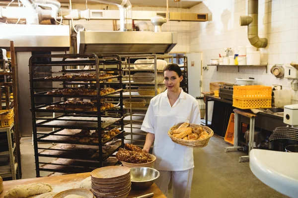 Ženské baker drží košík sladkých jídel — Stock fotografie