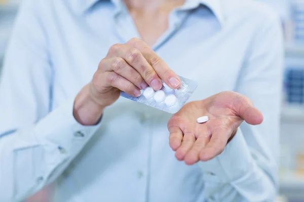 Farmacêutico tomar pílulas na farmácia — Fotografia de Stock