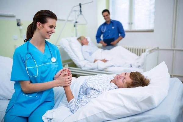 Zdravotní sestra utěšující pacienta v nemocnici oddělení — Stock fotografie