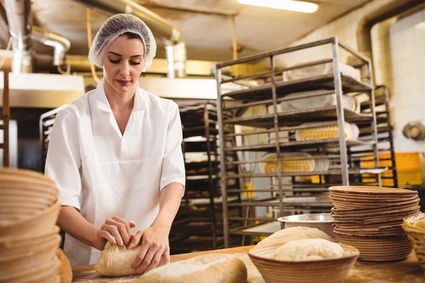 Panettiere femminile impastando una pasta — Foto Stock