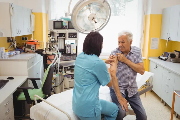 Médico que administra uma injeção ao doente — Fotografia de Stock