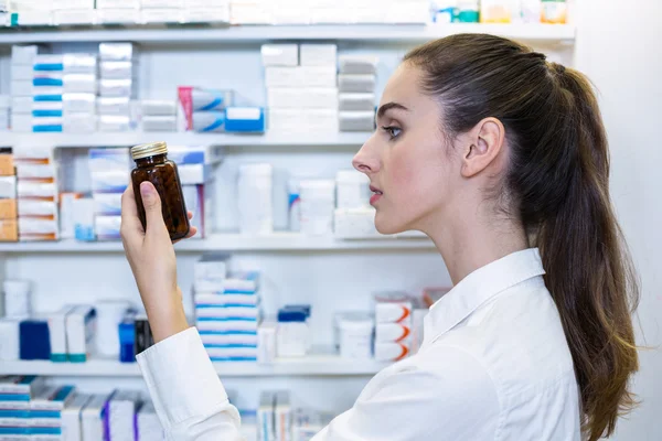 Apotheker kontrolliert eine Flasche mit Medikamenten — Stockfoto