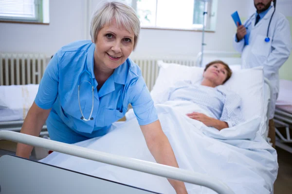 Infirmière écartant une couverture sur le patient — Photo