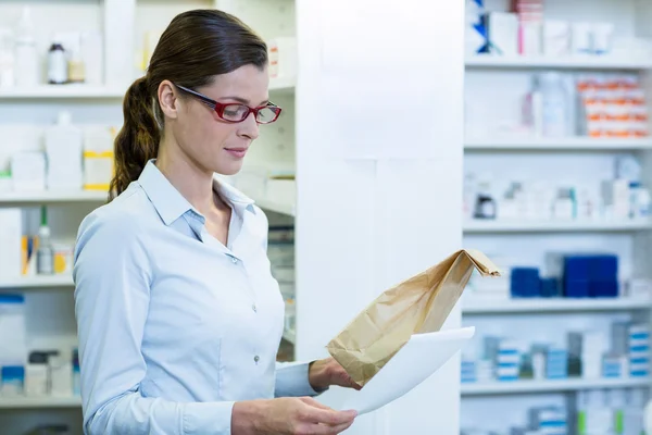 Pharmacist checking prescription and medicine package — Stock Photo, Image