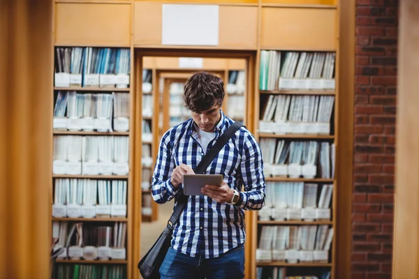 Estudante usando tablet digital na biblioteca — Fotografia de Stock