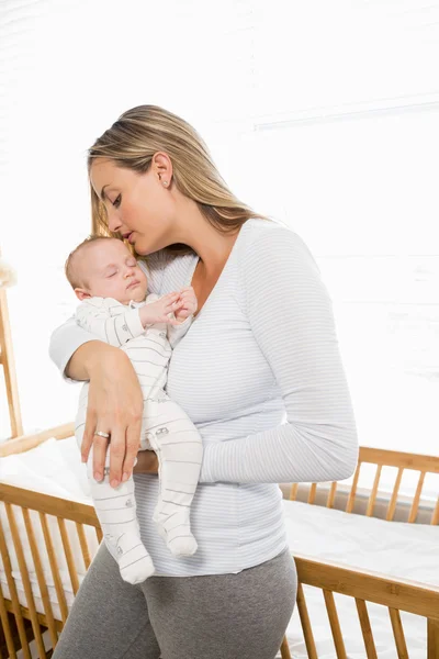 Mutter hält und küsst ihren kleinen Jungen — Stockfoto