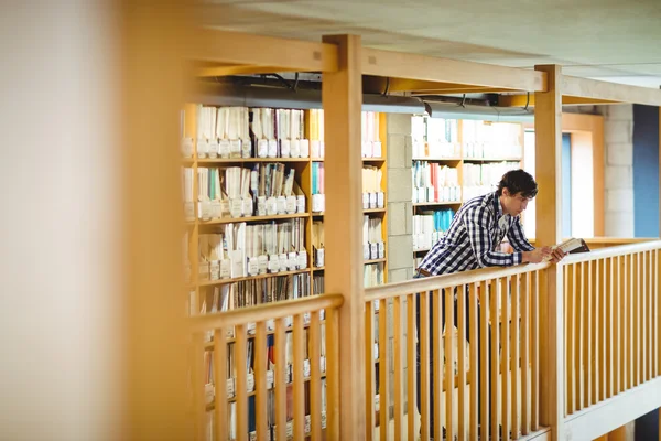 Student läsa bok i college library — Stockfoto
