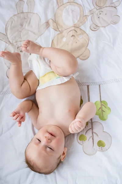 Cute baby lying on bed in bedroom — Stock Photo, Image