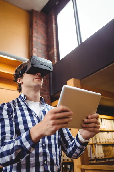 Estudante usando tablet digital e fone de ouvido de realidade virtual na biblioteca — Fotografia de Stock
