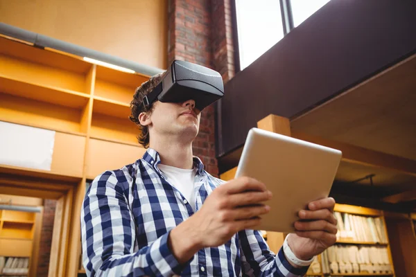 Estudante usando tablet digital e fone de ouvido de realidade virtual na biblioteca — Fotografia de Stock