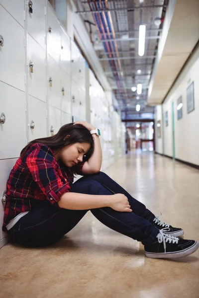 Deprimida estudante sentada no vestiário — Fotografia de Stock