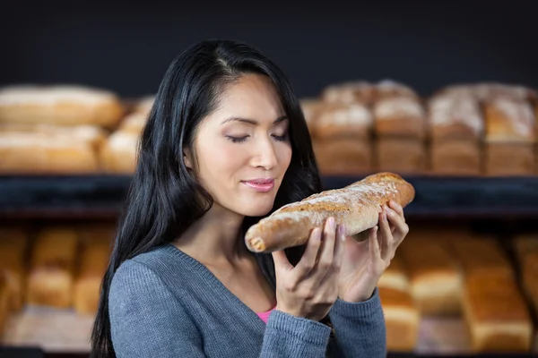 Woman smelling a baguette — Stock Photo, Image