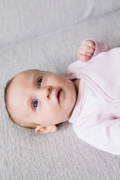 Baby lying on sofa in living room — Stock Photo, Image