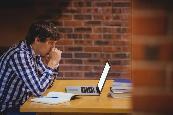 Przemyślane student korzysta z laptopa w bibliotece — Zdjęcie stockowe