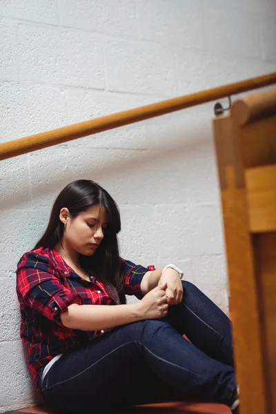 Upprörd kvinnlig student som sitter på trappan — Stockfoto