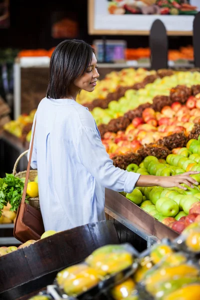 Mujer comprando frutas en sección orgánica — Foto de Stock