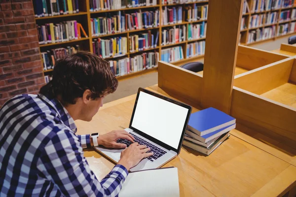 Estudante usando laptop na biblioteca — Fotografia de Stock