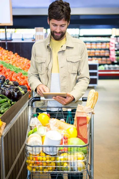 Homme utilisant la tablette tout en faisant des achats — Photo