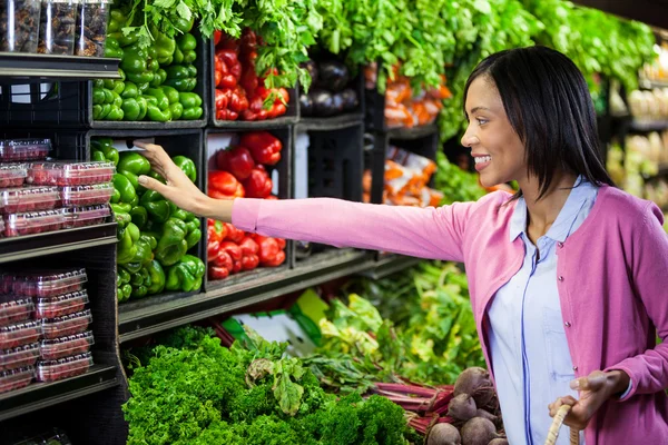 Mujer comprando verduras en sección orgánica — Foto de Stock