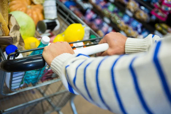 Muž s vozíkem v sekci s potravinami — Stock fotografie