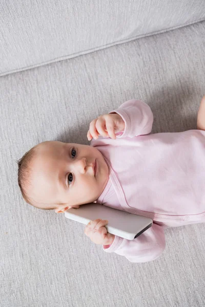 Baby lying on sofa in living room — Stock Photo, Image