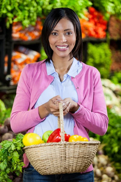 Γυναίκα που κρατά τα φρούτα και τα λαχανικά στο καλάθι — Φωτογραφία Αρχείου