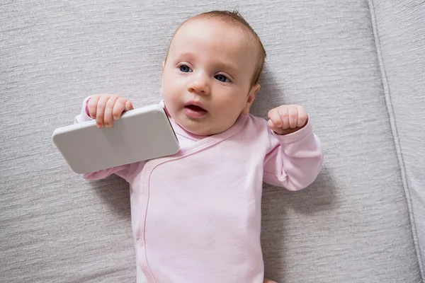 Baby lying on sofa in living room — Stock Photo, Image