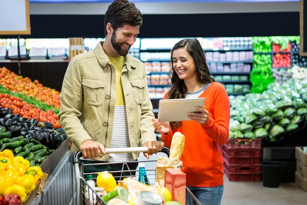 Casal usando tablet durante as compras — Fotografia de Stock