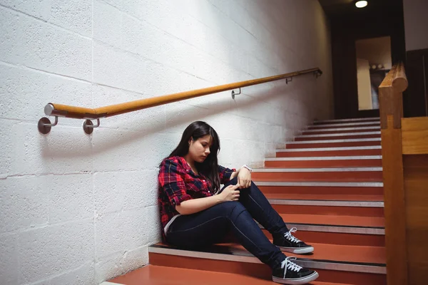Estudante feminina perturbada sentada na escada — Fotografia de Stock