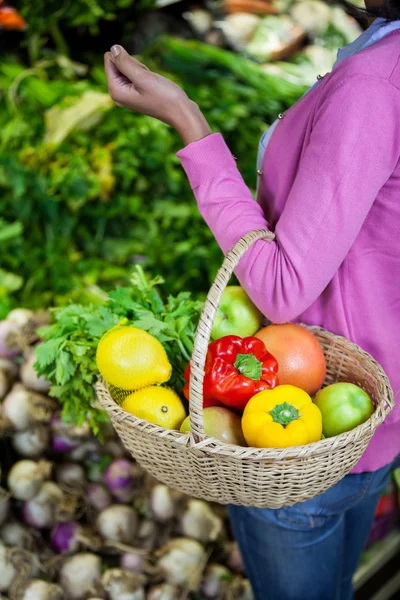 Perempuan yang memegang buah-buahan dan sayuran dalam keranjang — Stok Foto