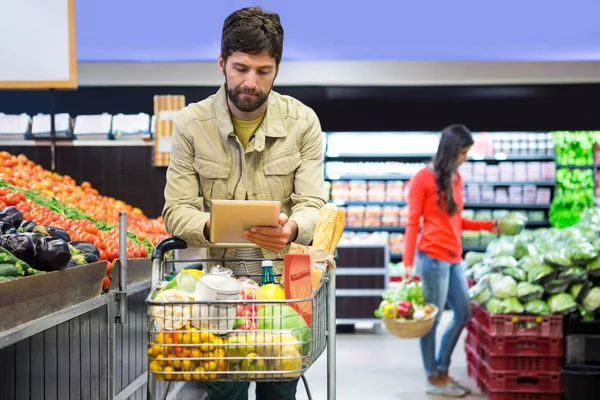 Hombre usando la tableta mientras compra — Foto de Stock