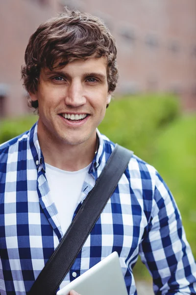 Smiling student standing in campus with digital tablet — Stock Photo, Image