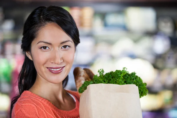 Woman holding groceries in paper bag — Stock Photo, Image