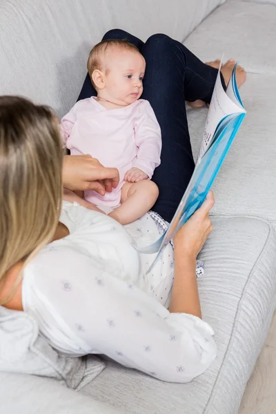 Mãe mostrando livro de história para seu bebê — Fotografia de Stock