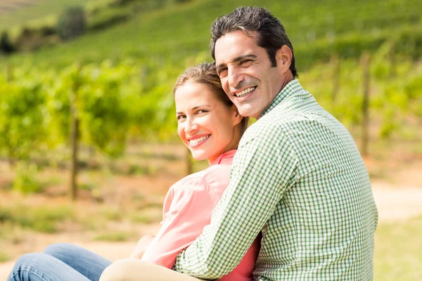 Gelukkige paar zitten in de wijngaard — Stockfoto