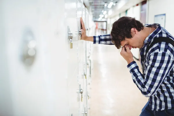 Sorgliga student lutande på locker — Stockfoto