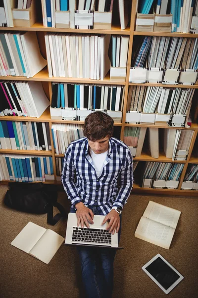 Uczeń korzysta z laptopa w bibliotece — Zdjęcie stockowe