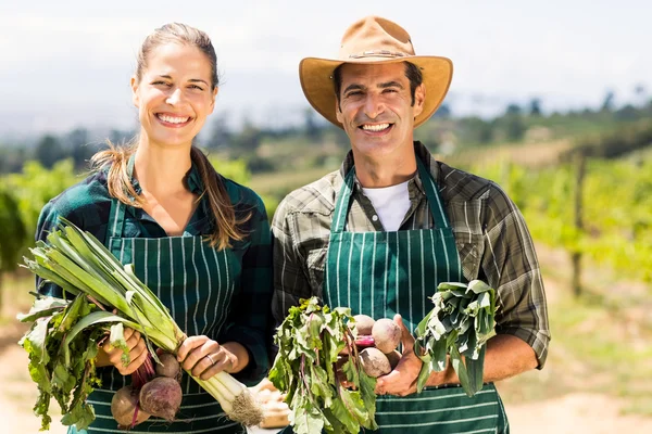 Pareja campesina sosteniendo verduras de hoja — Foto de Stock