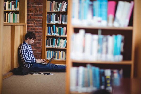 Uczeń korzysta z laptopa w bibliotece — Zdjęcie stockowe