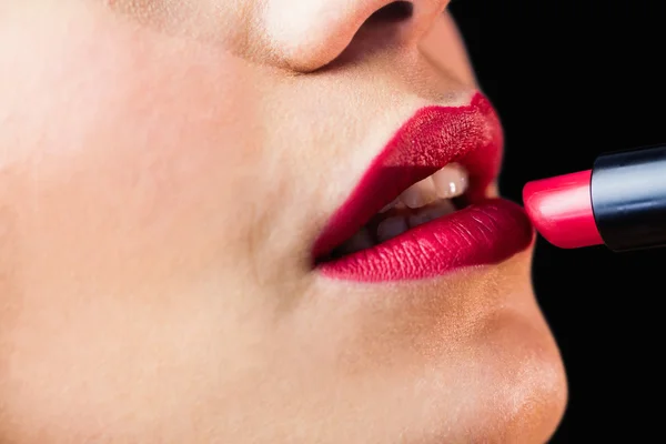 Mulher aplicando batom vermelho nos lábios — Fotografia de Stock