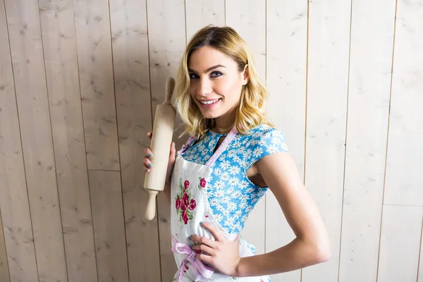 Woman in apron holding a rolling pin — Stock Photo, Image