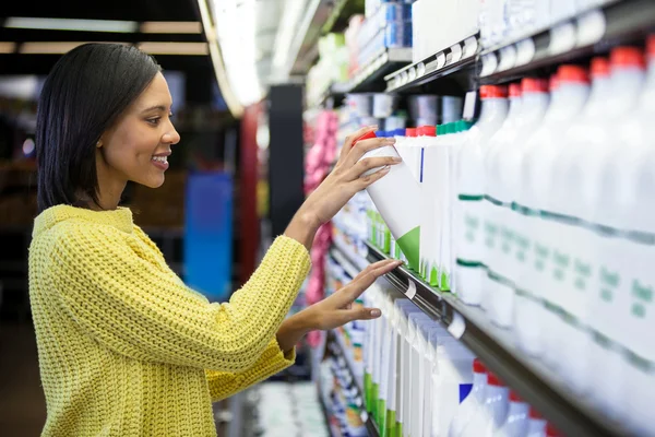 Mujer comprando leche de la sección láctea —  Fotos de Stock