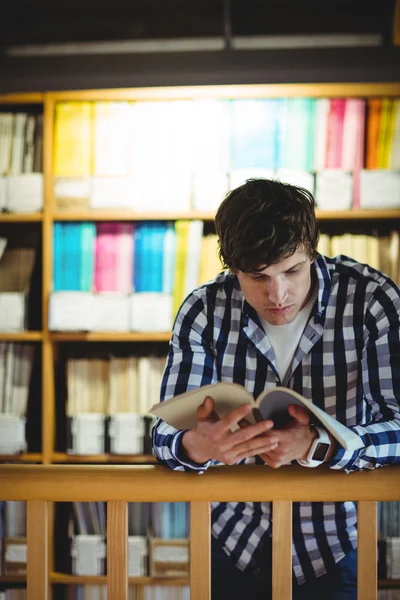 Student läsa bok i college library — Stockfoto