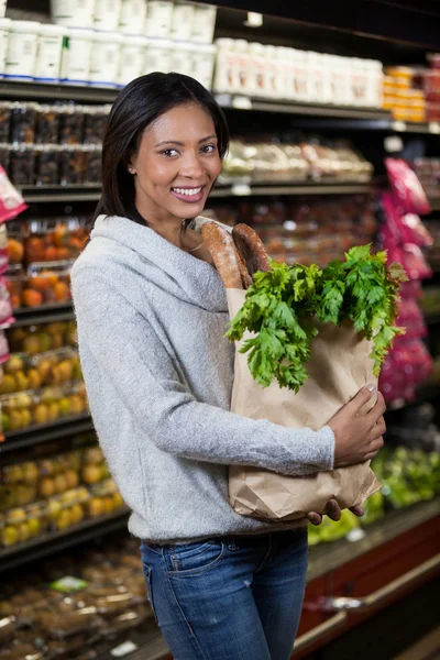 Mujer sonriente sosteniendo una bolsa de supermercado — Foto de Stock