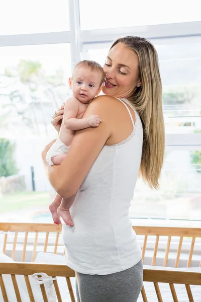 Mãe carregando seu bebê na sala de estar — Fotografia de Stock