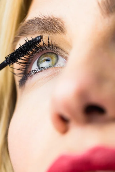 Woman applying mascara on eyelashes — Stock Photo, Image