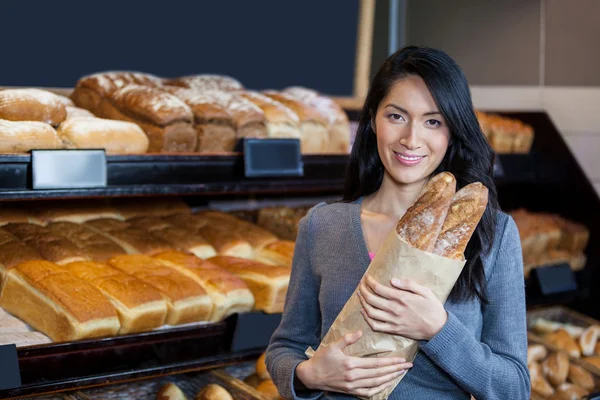 Nő a gazdaság bagettet élelmiszerbolt táska — Stock Fotó