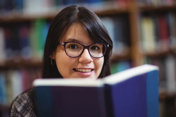 Female student holding book in college library — Stock Photo, Image