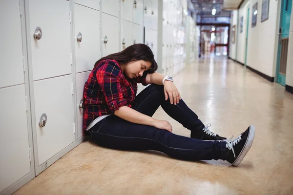 Deprimida estudante sentada no vestiário — Fotografia de Stock